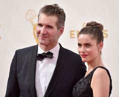 a man and woman standing next to each other on a red carpet