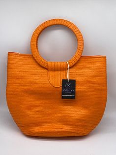 These beautiful handbags are made from Cana Flecha which is an indigenous palm fiber found in the northern territory of Colombia. They are beautifully hand crafted by the people from the Zenu tribes in Colombia. These handbags are colorful with vibrant colors, which is a pure reflection on the region and the warmness of these master artisans that work in this industry every day. Eco-friendly Orange Rectangular Straw Bag, Top Handle Beach Bag In Natural Fiber, Traditional Top Handle Straw Bag, Brown Handwoven Bag With Round Handle, Eco-friendly Handmade Bag With Round Handle, Eco-friendly Bags With Round Handle, Orange Handheld Beach Bag, Vacation Bags With Round Handle In Jute, Vacation Bags With Rolled Top Handles