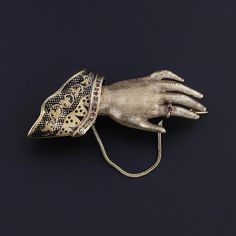 This rare antique, Victorian era brooch (circa 1860) features a hand of 14k gold with a black enamel lace cuff and red glass accents. The piece measures 1.5 inches by 2.2 inches wide, and it is in great condition.  The piece is hollow and weighs 7.28 grams.  We have many other fantastic offerings of period fine jewelry posted on our Etsy store, so please consider browsing our other items. We send all items in individually packaged gift boxes and offer layaway plans! + Trademark Antiques Shop Hom Victorian Hand Jewelry, Hands Jewelry, Hourglass Pendant, Hand Brooch, Victorian Hand, Brass Pin, Jewelry Post, Dope Jewelry, Silver Coat