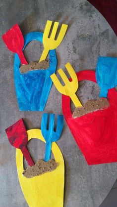 some colorful plastic utensils and sand on a table