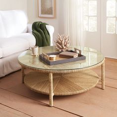 a living room with a couch, coffee table and other items on the wooden floor