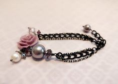 *** Only ONE in stock ***This fancy bracelet is made of a 20mm resin rose in light amethyst with Swarovski pearl, freshwater pearl and crystals dangles, and it's finished off with 2 thin black oxidized chain with a tint of gold and a thicker black oxidized chain on each side, with a matching lobster clasp.The bracelet measures approximately 6.5 inches in length plus an 1 inch extender. Should you require a shorter or longer chain, you can just leave me a message at checkout and I'll try my best Rose And Pearl, Fancy Bracelet, Purple Resin, Resin Rose, Needle Felted Cat, Cell Phone Charms, Rose Bracelet, Striped Cat, Light Amethyst