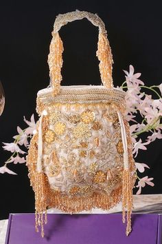 White velvet potli with floral, beads, crystal, dabka and swarovski hand embroidery. Comes with a detachable handle. - Aza Fashions Hand Embellished Pouch Bag For Reception, Hand Embellished Bags For Reception, Hand Embellished Potli Bag For Festivals, Hand Embellished Potli Bag For Festival Celebrations, Embellished Pouch Bag For Reception, Luxury Embellished Potli Bag For Evening, Luxury Embroidered Festive Bags, Festive Hand Embellished Gold Bag, Festive Gold Hand Embellished Bag