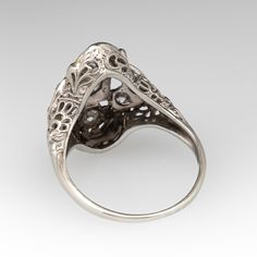 This fabulous Art Deco circa 1920s dinner ring features a pierced design with milgrain edging and etched floral designs. The ring is accented with nine (9) bead set old European cut diamonds. The ring measures 18.6mm at the top, rises 5.9mm above the finger, and tapers to 1.1mm wide by 0.7mm thick at the base of the shank. It is currently a size 5.5. Two of the diamonds have very minor chipping that cannot be seen without jewelers magnification. Dinner Ring, 1920s Art, 1920s Art Deco, Bead Set, European Cut Diamonds, Floral Designs, Diamond Cuts, Floral Design, Art Deco