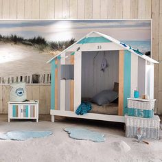 a child's bed with a beach theme on the wall next to a painting