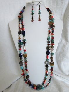 a necklace and earring set with multicolored beads on a mannequin