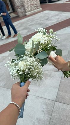 two people holding flowers on the street