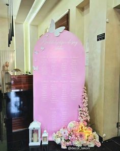 a large pink sign sitting on top of a black table next to a white candle