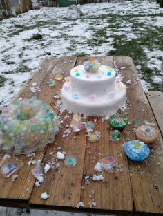 a cake sitting on top of a wooden table covered in frosted confetti