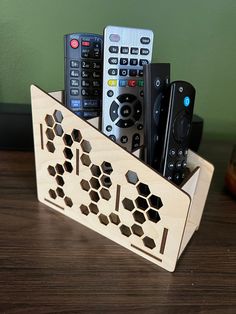 a wooden holder with remote controls in it