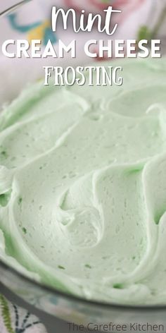 a bowl filled with green cream frosting on top of a table