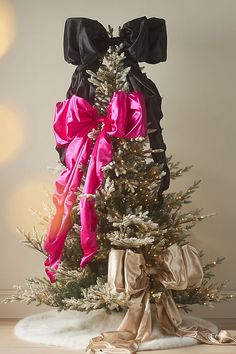 a decorated christmas tree with pink and black bows