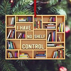 a wooden shelf filled with lots of books next to a christmas ornament that says, i have no shelf control