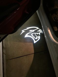 the side of a car with an illuminated logo on it