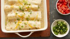 an enchilada with cheese and green onions in a casserole dish