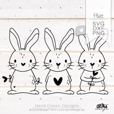 three rabbits with hearts in their hands on a wooden background, one is black and the other is white