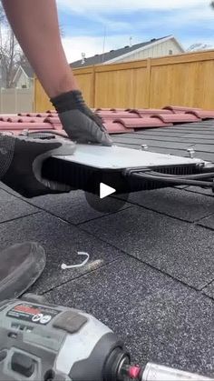 a man is working on the roof of his house with a power drill and an air conditioner