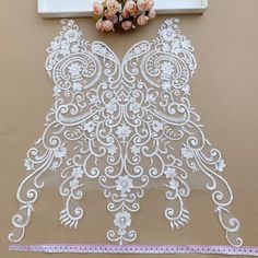 a piece of white lace with flowers on it