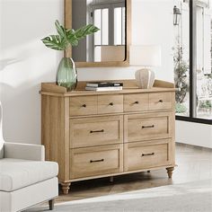 a living room scene with focus on the dresser and large mirror in the background,