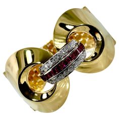 This Retro Period American bracelet embodies all the drama and high style of the best jewelry, art, and architecture of the era. A center platinum domed plate is set with a single line of square cut, natural rubies, flanked by 22 Late European cut diamonds. This appears to emerge from two imposing conical domes, each of which terminate in an iconic wide, purely retro, trapezoid link bracelet. Total approximate ruby weight is 1.00ct and total approximate diamond weight is .75ct. Overall quality is G/H color and VS1-2 clarity. Wearable length is 6 3/4 inches, the link bracelet measures 1 inch wide, and each conical dome measures 1 1/4 inches wide. The entire center motif rises a full 1/2 inch above the wrist when worn. The reverse of the clasp is stamped 14k. Gross weight 64 grams. American Bracelet, Retro Bracelet, Best Jewelry, Single Line, European Cut Diamonds, The Drama, Ruby Diamond, Square Cut, Gold Diamond Rings