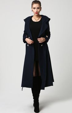 "This beautiful long wool coat features a double-breasted bodice and oversized silver buttons to create a distinct but classic military style. this winter coat features gorgeous navy blue wool, a polyester lining, and fun features like extra long sleeves, deep side pockets and back split vents. The self-tie belt makes it easy to accentuate your waist while the warm hood will stylishly shield you from the cold. DETAIL * 50% WOOL,50% POLYESTER * POLYESTER LINING * Epaulette with button * with warm Elegant Double-breasted Fall Peacoat, Blue Double-breasted Elegant Peacoat, Elegant Double-breasted Blue Peacoat, Double-breasted Long Peacoat For Fall, Blue Wool Coat With Double Button Closure For Fall, Elegant Winter Peacoat With Double Button Closure, Elegant Blue Double-breasted Wool Coat, Elegant Blue Pea Coat With Buttons, Elegant Blue Wool Coat With Buttons