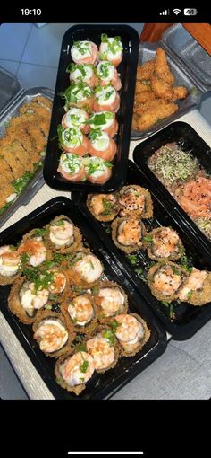 several trays filled with different types of food on top of a table next to each other