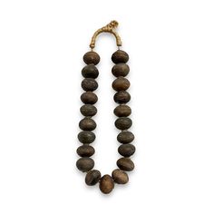 Add a touch of history and culture to your jewelry or home decor collection with these authentic African Clay Spindle Whorl Beads. Originating from Mali, these beads are handcrafted from terracotta clay and are rich in cultural significance and aesthetic appeal. The beads are estimated to be from the 1900-1950s making them vintage.  Sizing: Loose - 21 Beads: 2" Bead Diameter *Each strand measures approximately 19" in length* With Stand - 6.5"W x 4"D x 22"H Authentic Handcrafted Beads: Each bead Artisan Beaded Natural Jewelry, Artisan Natural Beaded Jewelry, Traditional Rondelle Beaded Necklaces For Gifts, Traditional Rondelle Beaded Necklaces As Gift, Artisan Beaded Necklace With Large Round Beads, Traditional Natural Color Round Jewelry, Artisan Beaded Necklace With Large Beads For Ceremonial Use, Traditional Rondelle Beaded Necklaces For Jewelry Making, Artisan Beaded Necklace With Large Beads For Ceremonial Occasions