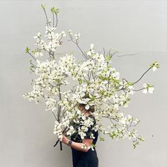 a woman holding a bouquet of white flowers