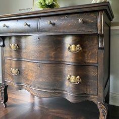 an antique chest of drawers with brass pulls and knobs on the top, in a living room