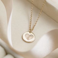 "A silver or gold circle charm pendant necklace customised with an engraved fingerprint and personalised on the reverse with a name or date. Perfect for Mother's day or a special birthday gift! Capturing every loop, whorl, and arch that makes up that unique print and then lasered in the shape of a heart on the surface of the charm. Stunningly different and each one very special. The perfect gift for Mum or Nanny. Made in sterling silver and can be plated in 18ct gold and hung from a fine chain. * * * How we get your fingerprint * * * 1. Once you have placed your order, a message with instructions on taking a fingerprint will be sent to you directly through Etsy. All you will need is a pencil, a piece of paper and Sellotape. 2. After you have taken the fingerprint you will need to send an i Newborn Footprints, Fingerprint Heart, Fingerprint Necklace, Heart Necklaces, Heart Charm Necklace, Gold Gift Boxes, Special Birthday Gifts, Fingerprint Jewelry, Gold Charm Necklace