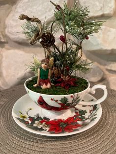 a teacup with a small figurine sitting on top of it