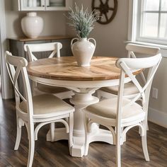 a dining room table with chairs and a potted plant on top of the table