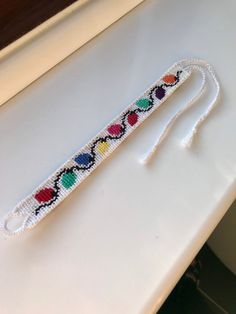 a piece of beaded string with hearts on it sitting on a table next to a mirror