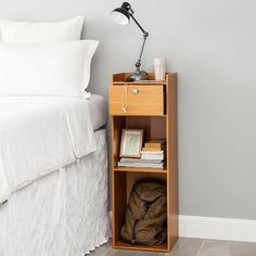 a bedroom with a bed, nightstand and white linens on the floor next to it