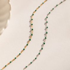 This beaded boho necklace is made of soft dainty, glistening emerald green beads that dance along your collarbone. It pairs wonderfully with a simple white blouse, but also goes well with a fancier dress for an evening out! Stunning and stylish, this beautiful beaded charm necklace adds a fun, flirty touch to any outfit. Material: High Quality Solid 925 Sterling Silver. Finish: Sterling Silver ∙ 18K Gold Featuring a dainty Beaded Necklace with ~2mm Emerald Green Beads spaced ~5mm apart, with adj Dainty Green Beaded Necklaces With Round Beads, Dainty Green Beaded Necklace With Round Beads, Green Beaded Chain Choker As Gift, Elegant Green Beaded Necklaces With Polished Beads, Dainty Green Beaded Necklaces, Elegant Green Beaded Necklace With Round Beads, Elegant Beaded Emerald Necklaces, Delicate Chain Beaded Necklaces For Party, Elegant Beaded Emerald Necklace