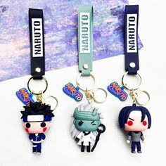 three keychains with cartoon characters on them sitting in front of a purple background