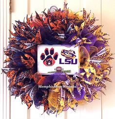 this wreath is decorated with orange, purple and yellow ribbons that have the team's logo on it