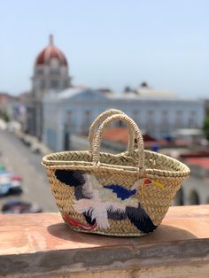 The Margarita Bag is a mini version of the traditional Moroccan Panier Basket. It´s handmade by artisans in Marrakech, that weave the basket out of palm leaves. This trendy mini handbag has a beautiful natural straw color, finished with short handles in the same material. It features a fun embroidered and sequined crane on the front. Material: Palm leaf straw, sequins MADE IN SPAIN Size: 12 1/2 x 10 x 8 inches Due to its handmade craftsmanship, bags can vary slightly in size and color and may ha Mini Handbag, Mini Handbags, Palm Leaves, Marrakech, Straw Bag, Straw, Handles, Weaving, Im Not Perfect