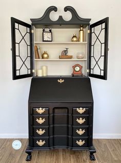 an old fashioned desk is painted black and gold