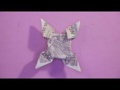 an origami star made out of money on a purple background