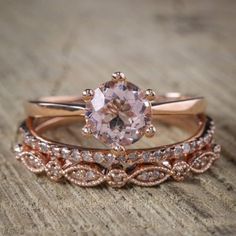 two wedding bands with an oval cut diamond in the center and rose gold band on each side