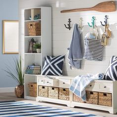 an entryway with baskets and towels hanging from hooks on the wall next to it