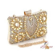 Possessing a handbag like this is a true testament to your exquisite taste and love for luxury. This dazzling clutch is designed to be the centerpiece of any glamorous ensemble. Its surface is encrusted with meticulously placed crystals and gems, creating a radiant, eye-catching effect that sparkles with every movement. The intricate floral patterns made from golden stones add a layer of sophistication and timeless elegance. The top clasp is equally adorned, ensuring that every detail of this ha Glamorous Handheld Evening Bag With Bling, Glamorous Embellished Evening Bag As Gift, Glamorous Embellished Evening Bag For Gift, Glamorous Bling Handheld Evening Bag, Gold Bags With Rhinestones For Gala, Glamorous Rectangular Embellished Evening Bag, Embellished Clutch Bag For Events, Elegant Handheld Evening Bag With Bling, Glamorous Bling Bags As A Gift