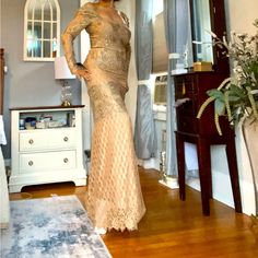 a woman standing in a living room next to a dresser