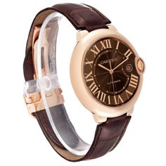 Cartier Ballon Bleu 42 mm Rose Gold Automatic Mens Watch W6920037. Automatic self-winding movement. 18K rose gold case 42.0 mm in diameter. Fluted crown set with the blue sapphire cabochon. 18K rose gold smooth bezel. Scratch resistant sapphire crystal. Brown guilloche dial with roman numerals. 18k rose gold sword shape hands. Minute markers around an inner ring. Date window at 3 o'clock aperture. Brown leather strap with 18K rose gold deployant buckle. Luxury Automatic Cartier Watch, Rose Gold Watches With Skeleton Dial, Classic Watch Accessories With Metal Dial In Rose Gold, Classic Rose Gold Watch With Metal Dial, Classic Rose Gold Watch Accessories With Metal Dial, Luxury Brown Watches With Subdials, Rose Gold Automatic Watches, Luxury Automatic Watch Accessories By Cartier, Timeless Rose Gold Watch With Skeleton Dial