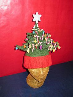 a knitted christmas tree hat on top of a mannequin head