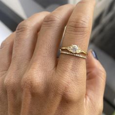 a woman's hand with a diamond ring on top of her finger and an engagement band