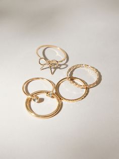 This set of dainty rings consists of a variety of designs including a classic tied bow ring. Whether you want to stack together or wear individually, this set offers a little bit of everything. Vute Rings, Cutr Rings, Cute Little Ring, Aesthrtix Rings, Cute Basic Rings, Cute Gold Rings For Teens, Simple Dainty Rings, Cute Aesthetic Rings, Minimalist Ring Stack