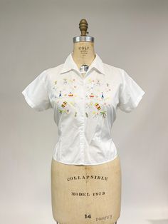 "Another utterly adorable vintage blouse from the 1950s! Soft, lightweight cotton or cotton blend with button front, small collar and short sleeves. Front of blouse is embroidered with little people in sombreros, cactus, palm trees and women in full skirts. No labels present, was likely purchased as a souvenir from a vacation taken long ago. Very good condition, faint dark line from shoulder halfway down (that looks to be a manufacturing defect from the cotton) and not really a flaw. Small white Military Ball, Full Skirts, Vintage Blouse, Wiggle Dress, Green Satin, Evening Party Dress, Blouse Vintage, Little People, Blouse Top