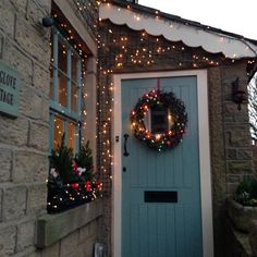 a blue door is decorated with christmas lights